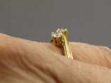 la main d'une femme tenant une bague en or sertie d'un diamant