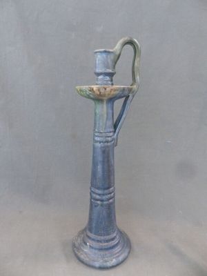 un vase bleu surmonté d'un oiseau