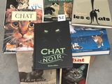 Plusieurs livres sont empilés les uns sur les autres par terre.
