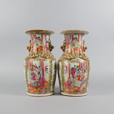 une paire de vases chinois ornés de motifs colorés, posés sur une table