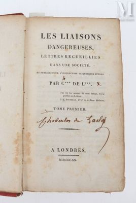un livre ouvert, sur lequel figure un titre écrit à la main, posé sur une table