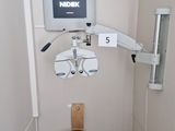 an image of a medical room with a monitor and a chair