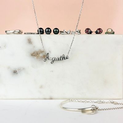 un coffret en marbre blanc sur lequel sont posés un collier et une bague