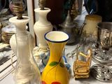 a yellow vase sitting on top of a table next to other vases