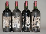 quatre bouteilles de vin sont alignées sur une table