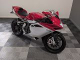 une moto rouge et blanche garée sur un sol à damier