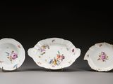 trois pièces de porcelaine ornées de motifs floraux, posées sur une table