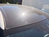a cat sitting on top of the roof of a car