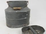 an old metal bucket with a wooden handle next to a metal container with a wooden handle