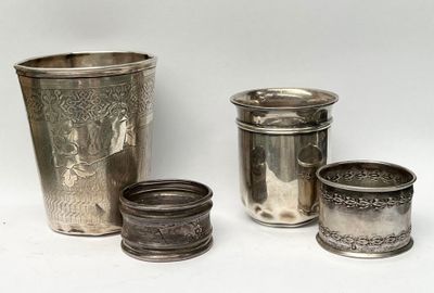 quatre tasses en argent posées les unes à côté des autres sur une surface blanche
