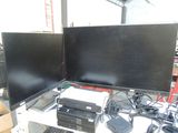 two computer monitors sitting on a desk with a keyboard and mouse