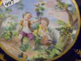 a plate with a picture of two children picking grapes