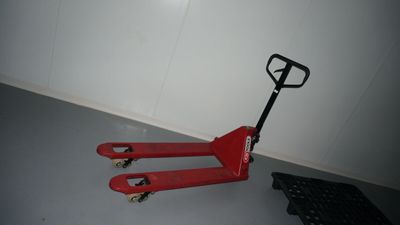 a red hand truck that is sitting on the floor
