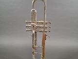 an image of a silver trumpet on a silver surface