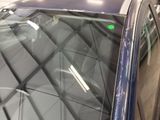 a blue car with a green sticker on the windshield