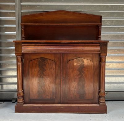 a wooden cabinet with two doors and a shelf above it