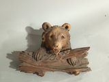 a bear head on a piece of wood on a table