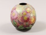 a small vase with flowers painted on it on a white surface