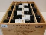 bottles of wine in a wooden crate on a white table