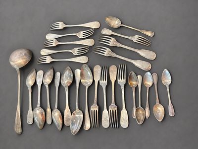 a lot of spoons and forks laid out on the table