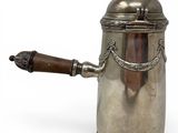 an antique silver coffee pot with a wooden handle on a white background
