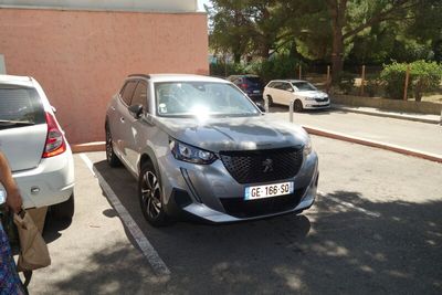 une voiture argentée garée dans un parking à côté d'un bâtiment