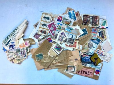 une pile de timbres posée sur une table, à côté d'un rouleau de papier