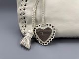 porte-monnaie en cuir blanc orné d'un pendentif en forme de cœur sur le côté