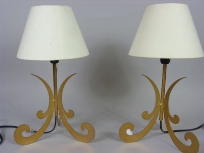 pair of brass table lamps with white lampshads on each of them