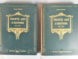 pair of green books with gold lettering on them sitting on a white surface