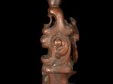 an old wooden candle holder with a candle on top of it