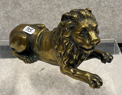 une statue représentant un lion couché par terre