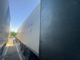 a truck that is driving down the street next to another truck