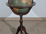 a small table with a globe on it and a shadow on the wall