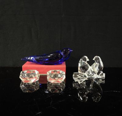 deux oiseaux en verre posés sur une boîte rouge