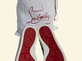 pair of red and white shoes in a white bag on a white surface