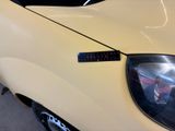 a close up of a car ' s headlight with a sticker on it