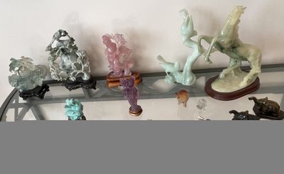 de nombreuses figurines en verre posées sur une étagère en verre