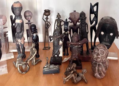 a lot of african statues on display on a table