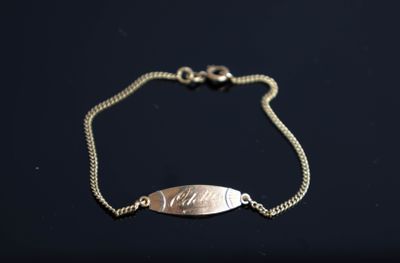 un gros plan d'un bracelet en argent orné d'un poisson