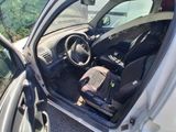 the interior of a car with the door open and a suitcase in the passenger seat