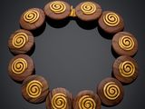 a close up of a wooden bracelet with spiral designs on it