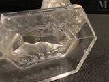 a clear glass vase with a flower inside of it on a table