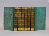 trois livres sont empilés sur une surface blanche