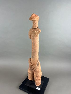 sculpture représentant une girafe debout sur un socle noir, sur fond gris
