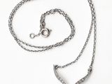 un gros plan d'un collier composé d'une pierre bleue montée sur une chaîne