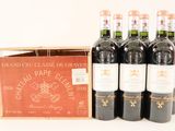 six bottles of red wine in a wooden box on a white surface