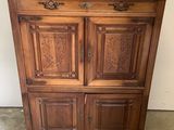 un vieux meuble en bois avec deux portes et un tiroir sur le dessus