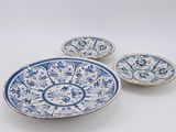 trois assiettes bleues et blanches à motifs sur une surface blanche