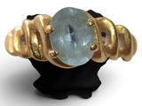 an image of a gold ring with a blue topaz stone